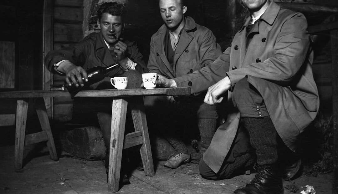 Redaktionsteam sichtet historische Fernseharchivfotos an einem Tisch